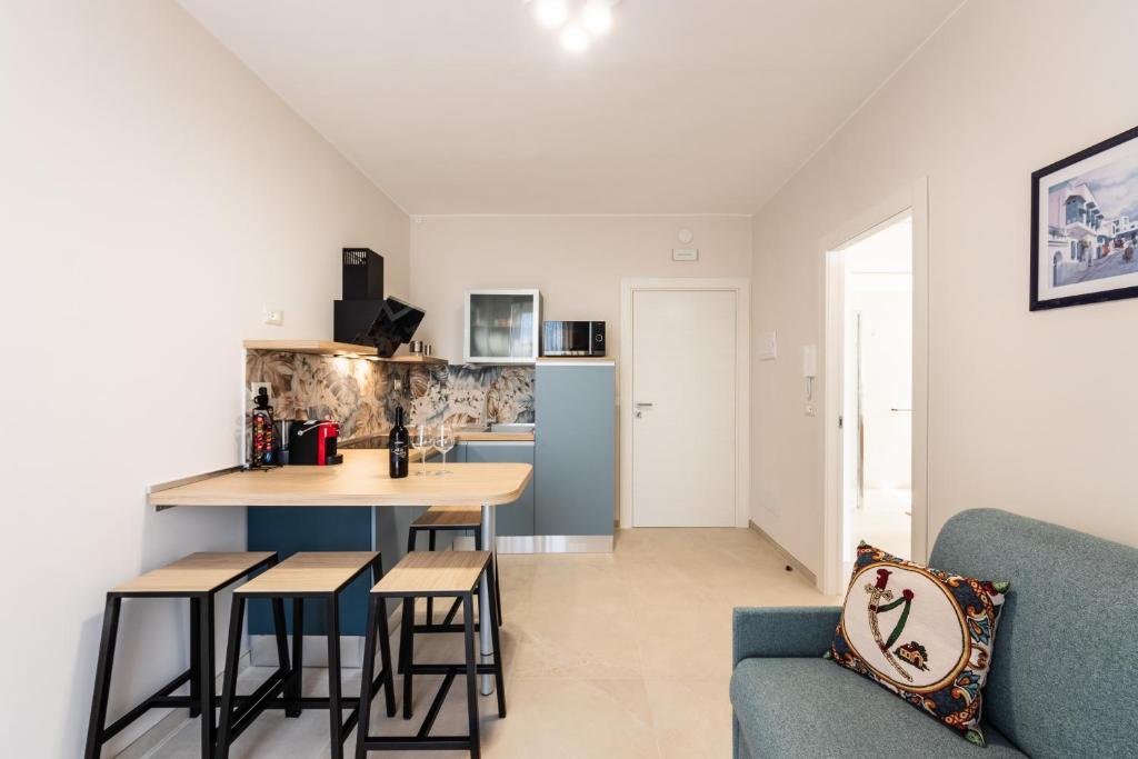 a kitchen and living room with a table and a couch at Casa Amarantia-Appartamento 1 in Noto
