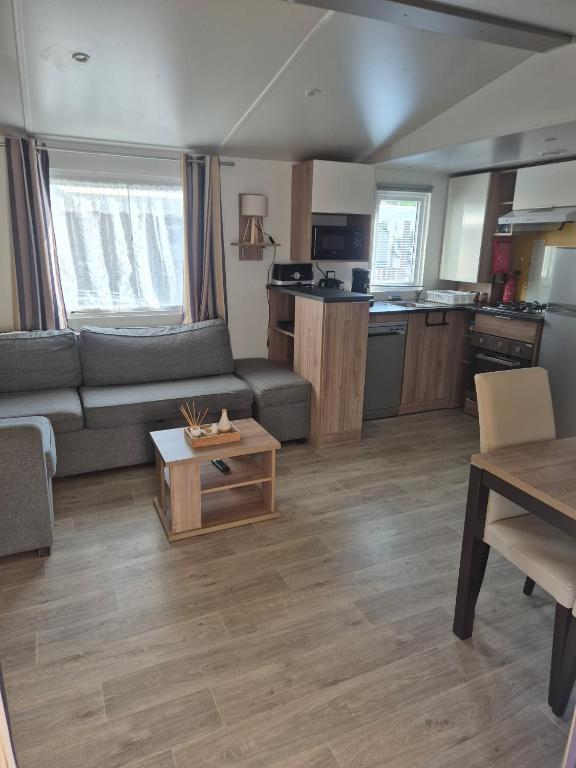 a living room with a couch and a table at Mobilhome, Camping Le Marisol in Torreilles
