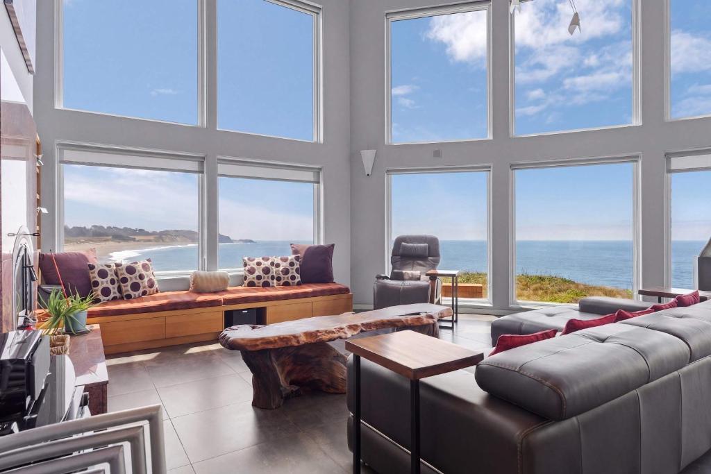 a living room with a large room with windows at Pacific Bliss Haven in Gualala