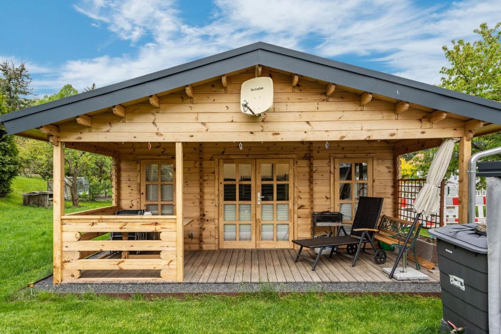a wooden cabin with a black roof at Adler Sommerhaus Oderwitz in  Oderwitz