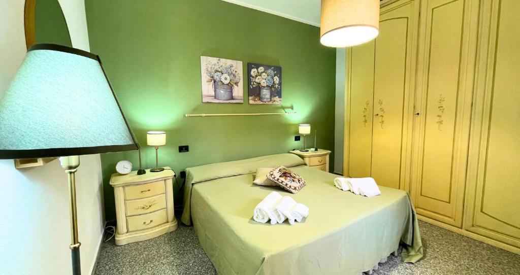 a green bedroom with a bed with towels on it at The Light House - Olbia centro in Olbia