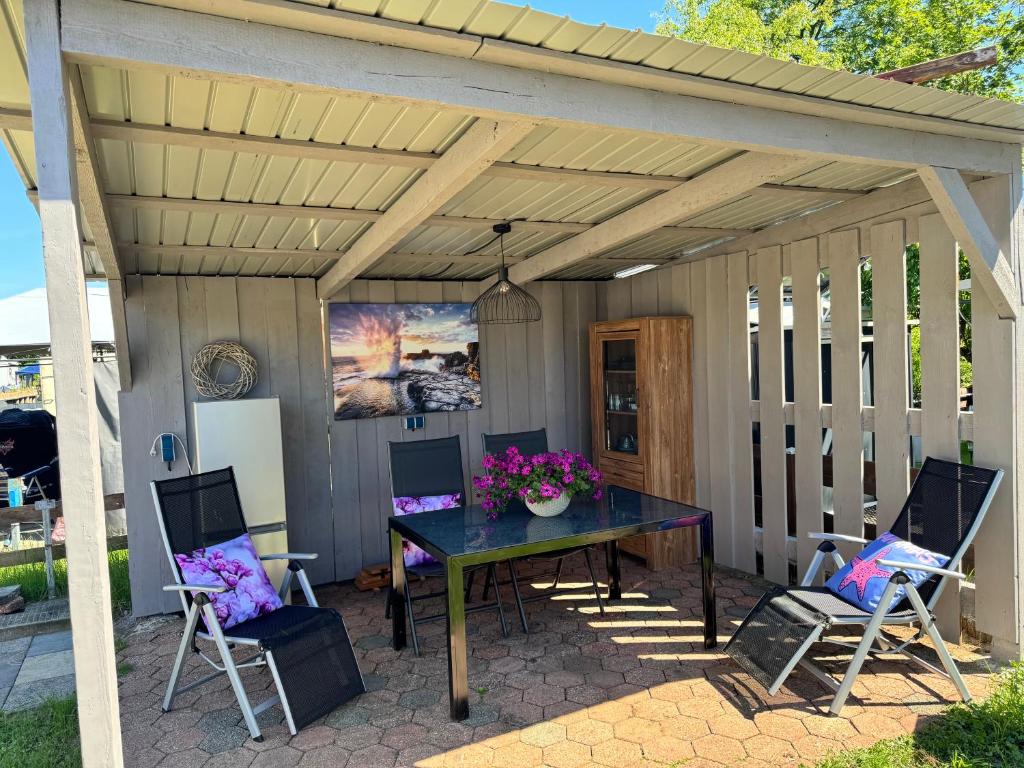 a pergola with a table and chairs on a patio at Kleine Auszeit in Schermbeck