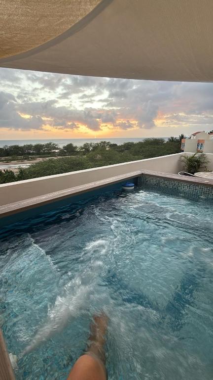 a swimming pool with a persons legs in the water at Sea View Rooftop in Cabo Rojo