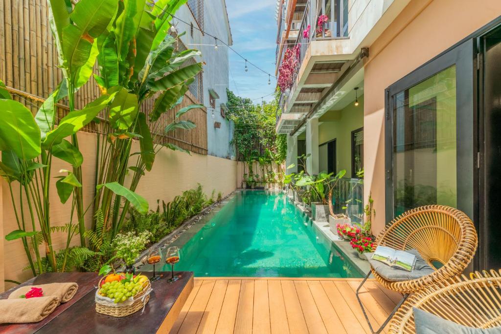 a swimming pool in a balcony with chairs and a table at The Coastal Haven pool villa in Hoi An