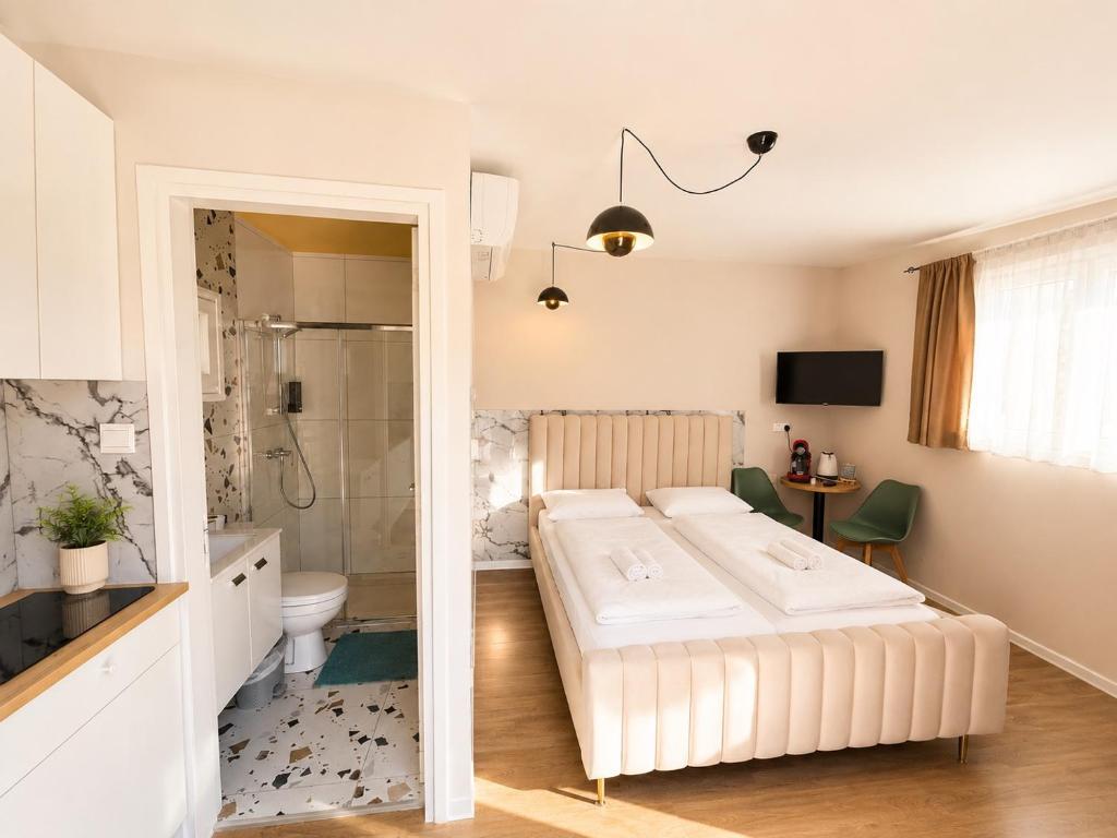 a bedroom with a large bed and a bathroom at Moder Studio Nr15 in Limassol