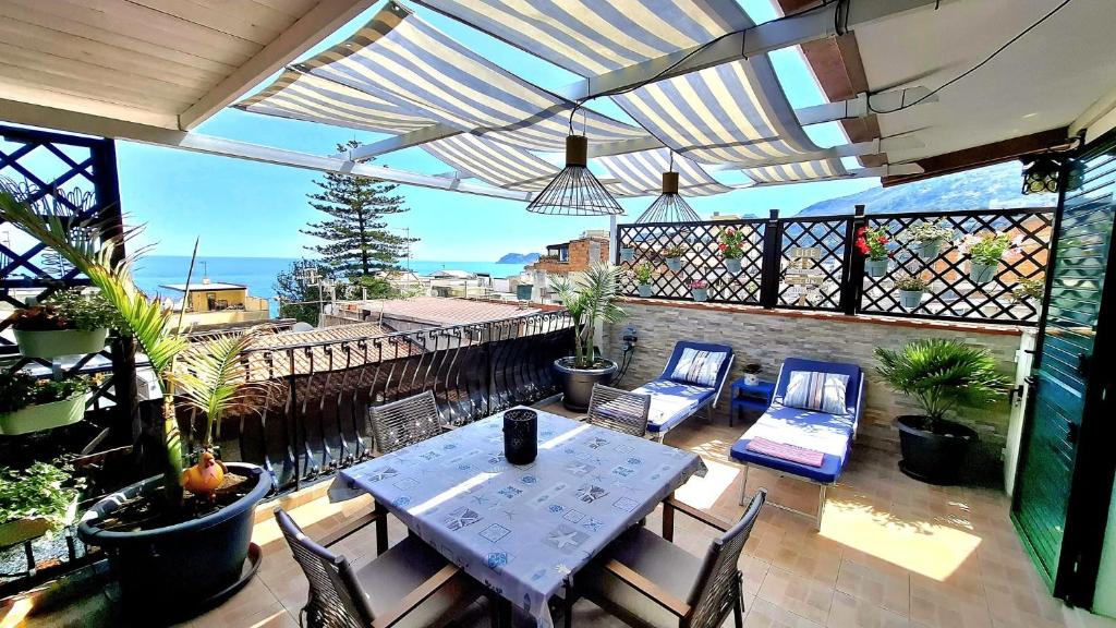 a patio with a table and chairs on a balcony at Terrazza Enjoy in Letojanni
