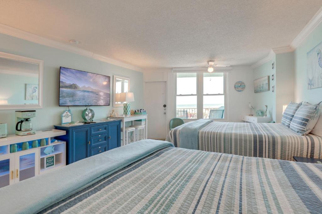 a bedroom with two beds and a tv on the wall at Daytona Beach Studio w/ Ocean View + Amenities! in Daytona Beach