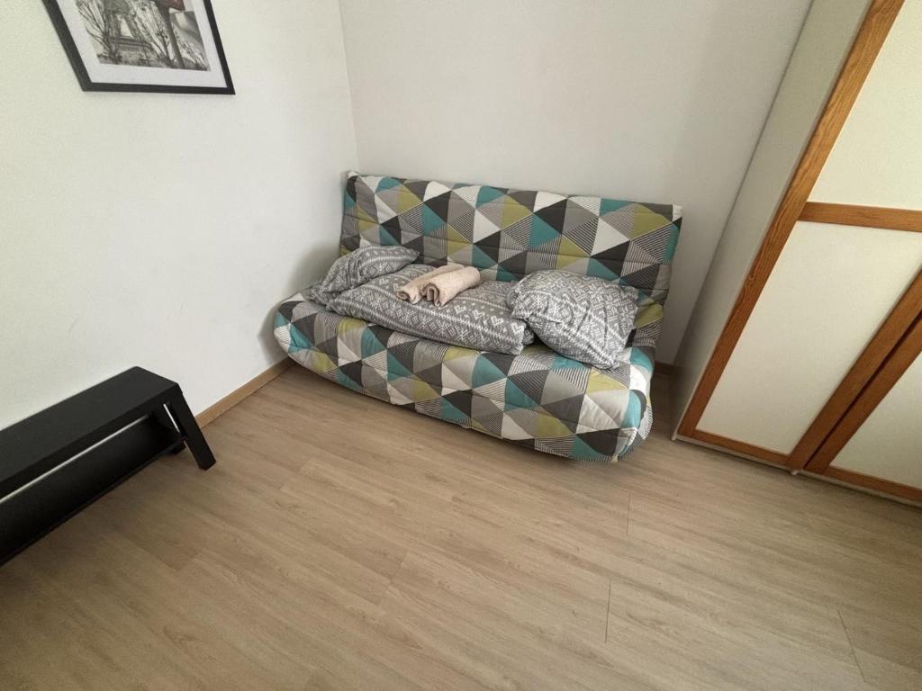 a couch sitting in a corner of a room at Le Saint Vaast - Studio au centre d'Arras in Arras