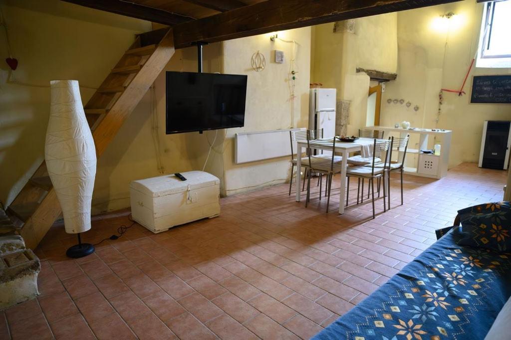 a living room with a tv and a table and chairs at Loft in cisterna romana in Amelia