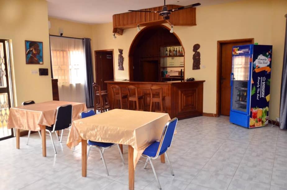 a kitchen with two tables and a refrigerator at Peace Vil in Kuto