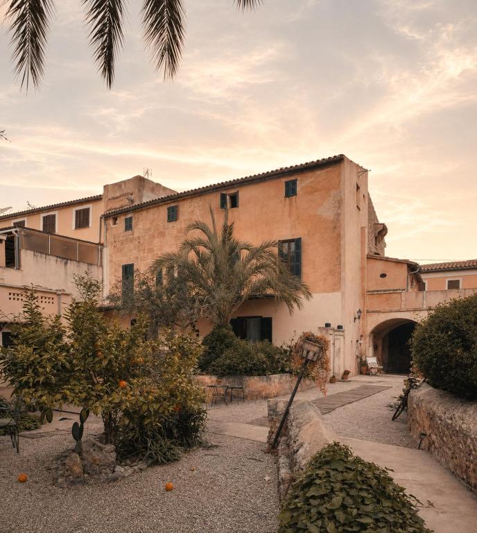an old building with a palm tree in front of it at Casa Mona, Turismo de Interior in Llubí