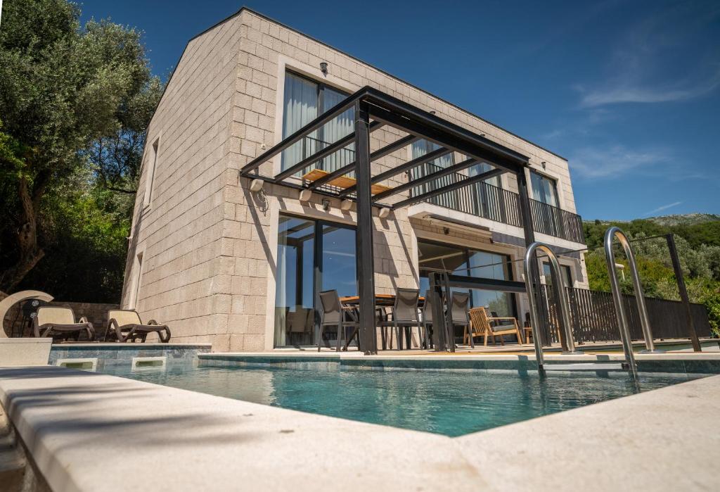 a house with a swimming pool in front of a house at Elysium Villa in Kaluđerac