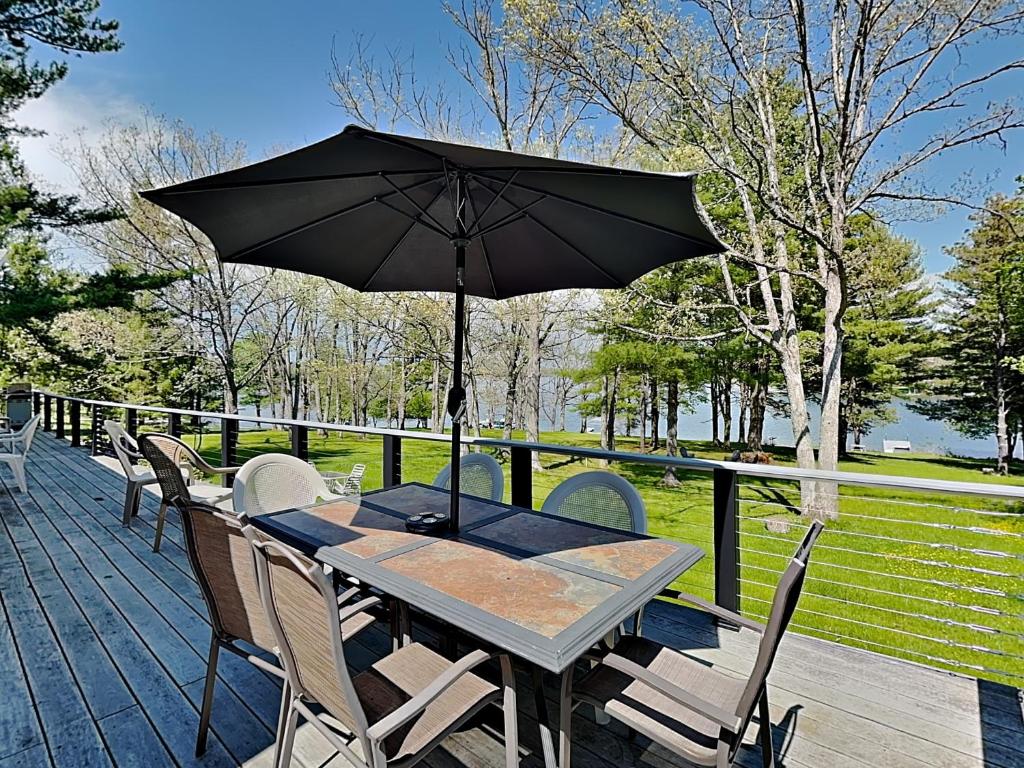 a wooden table with an umbrella on a deck at Just Around the Dilly in Swanton