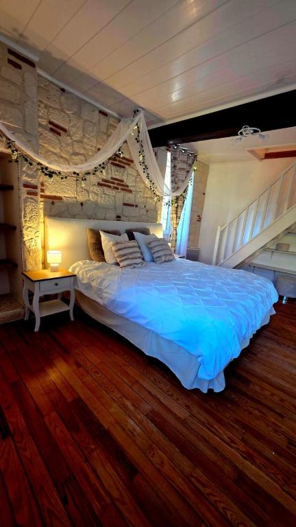 a bedroom with a large bed with blue sheets at Ecrin d'exception avec jacuzzi et salon cinéma in Penne-dʼAgenais