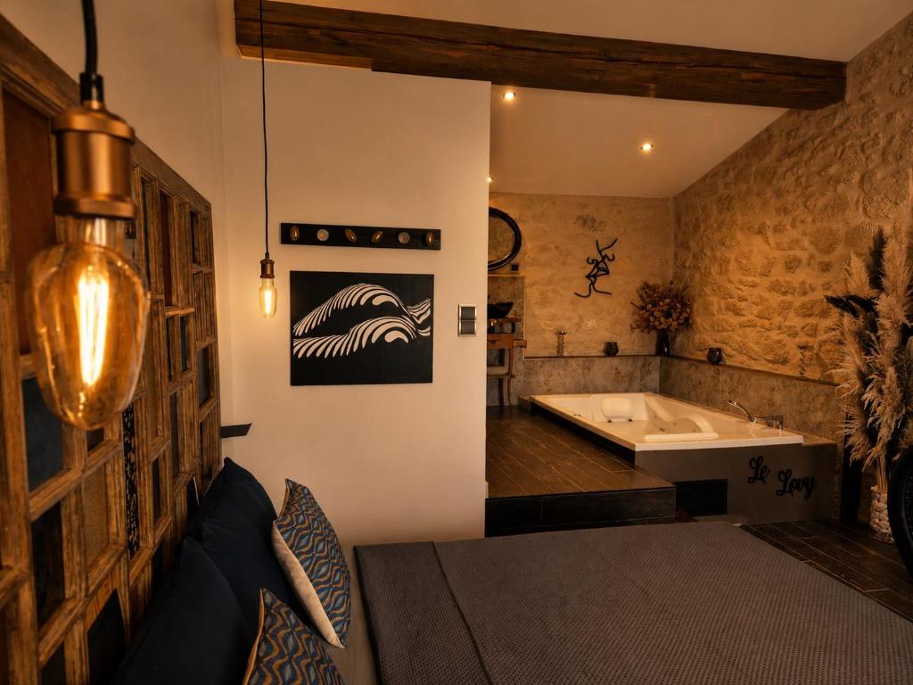 a bathroom with a bath tub and a bath tub at Le Lovy , Studio indépendant avec Jacuzzi in Cézac
