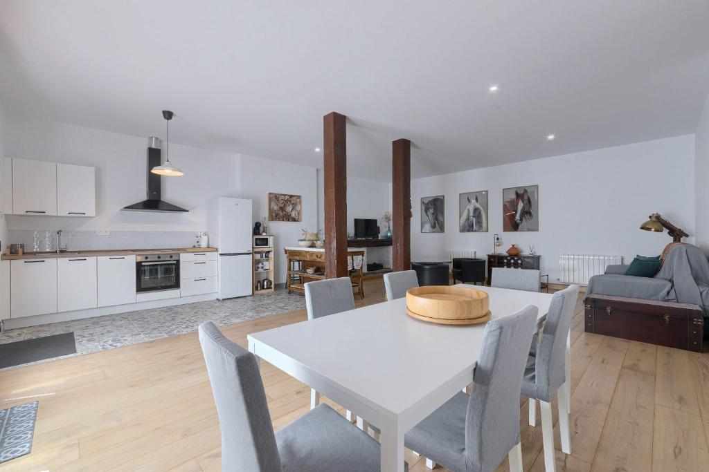 a kitchen and living room with a white table and chairs at Casa Eleizpe by Next Stop Bilbao in Ergoyen