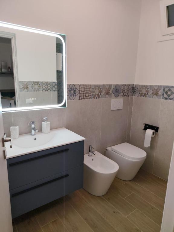 a bathroom with a sink and a toilet and a mirror at Casa Aurora & Santiago in Trapani