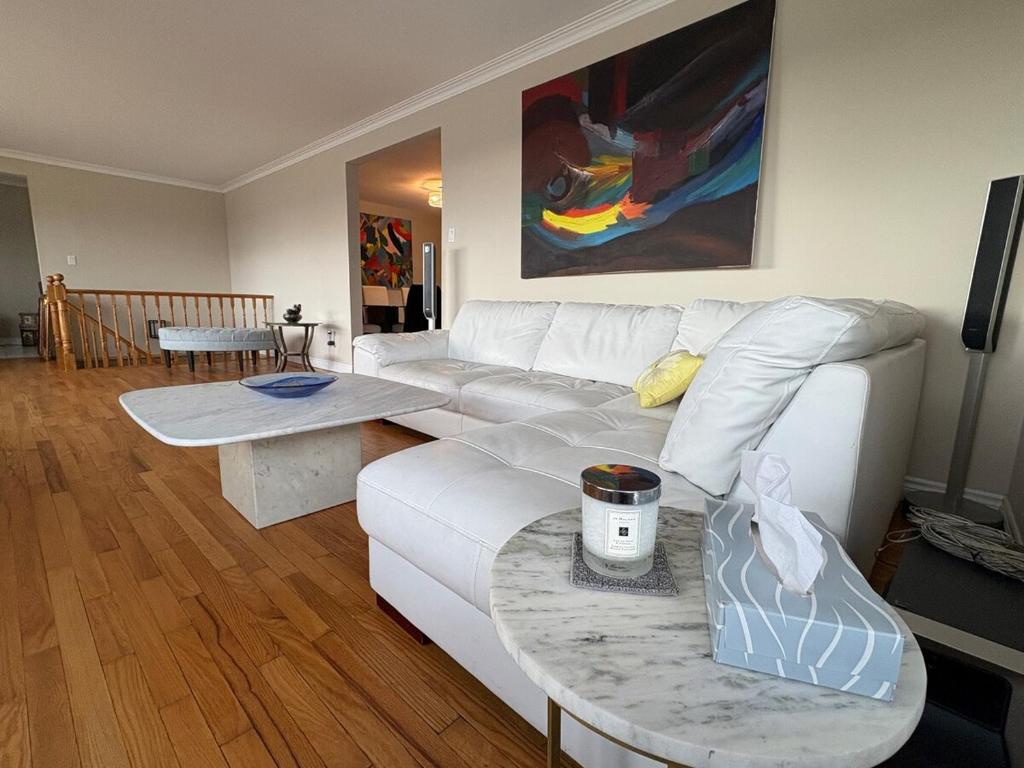 a living room with a white couch and a table at Spacious Cottage Style Home in Toronto