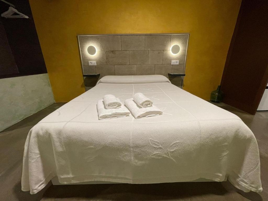 a white bed with two towels on top of it at Casa O'Tinte in Alquézar