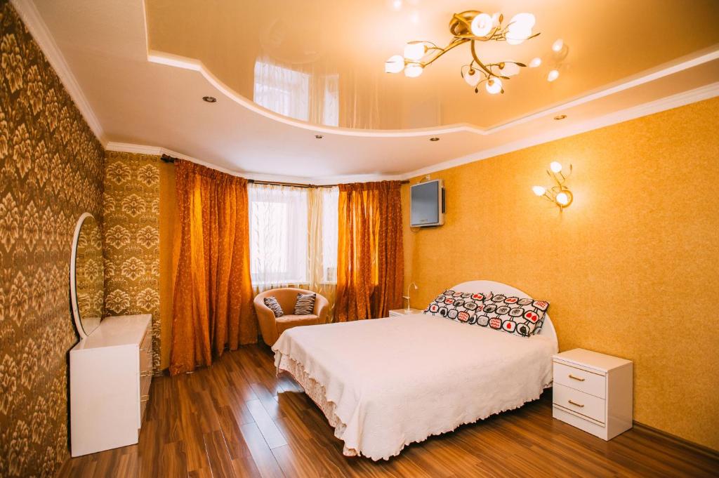 a bedroom with a bed and a chandelier at Kakaduhome Guest Rooms in Khabarovsk
