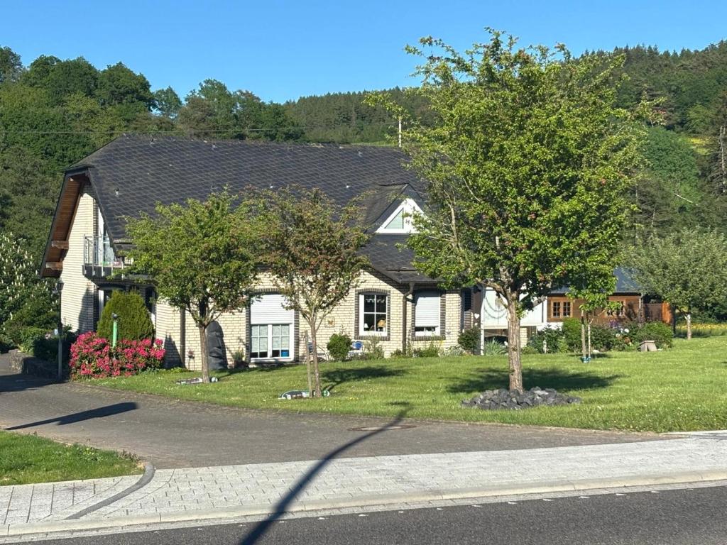 a white house with trees in front of it at Appartment Haus Müller in Kelberg