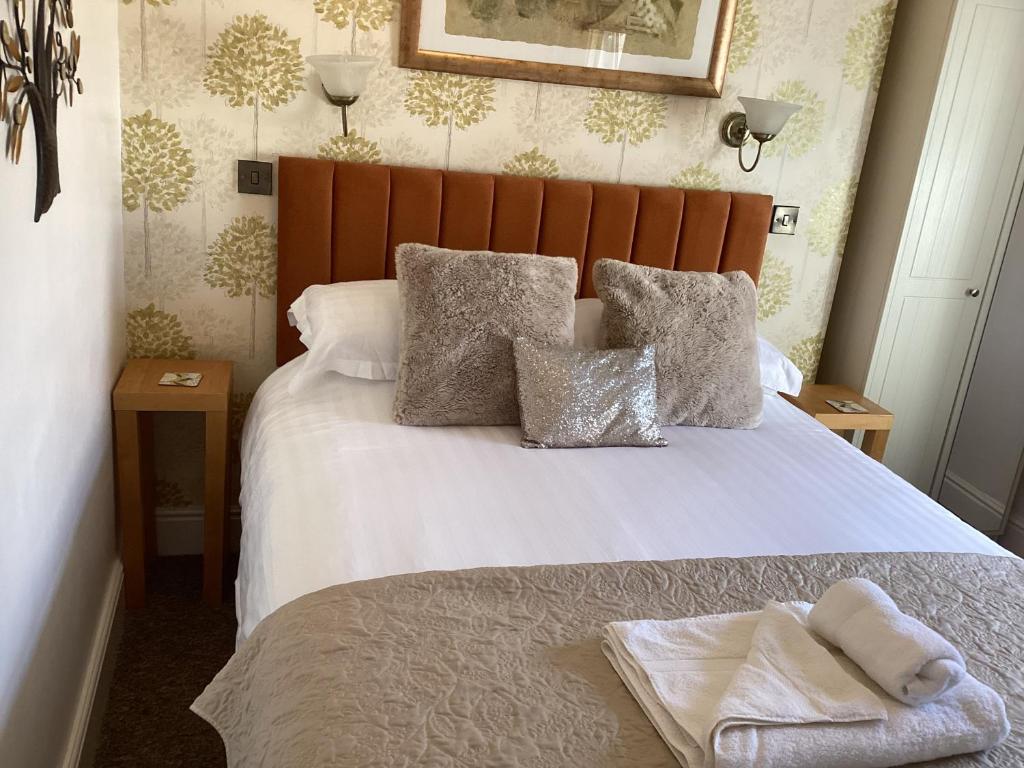 a bedroom with a white bed with pillows at Forest Guest House in South Shields