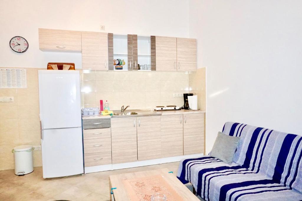 eine Küche mit Kühlschrank und eine Couch in einem Zimmer in der Unterkunft Rosette suites Trogir Seget Vranjica in Seget Vranjica