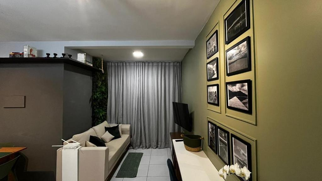 a living room with a couch and pictures on the wall at Apartamento Moderno em Floripa - Ideal para Famílias in São José