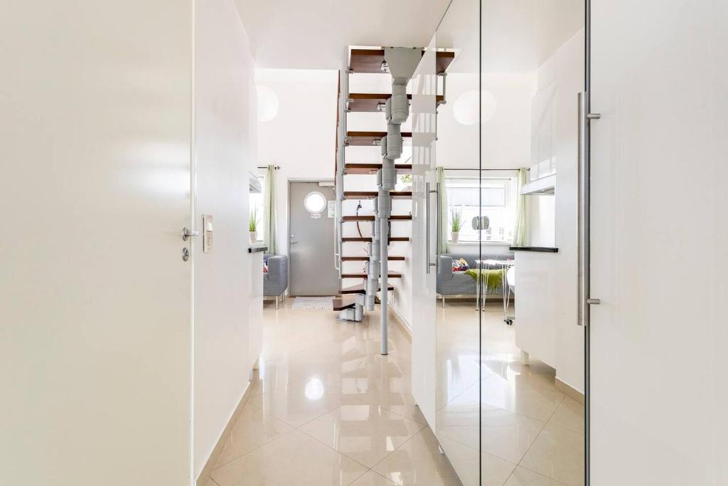 a hallway with a staircase and a room with white walls at Staylong Hotell in Täby