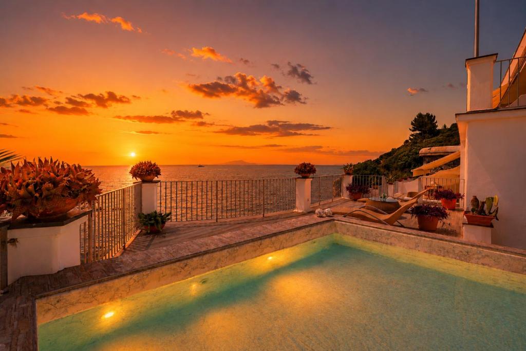 a swimming pool on the roof of a house with a sunset at Villa Lia in Massa Lubrense