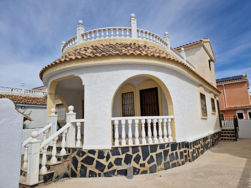 a white house with a balcony on top of it at Villa Oliver in Mazarrón