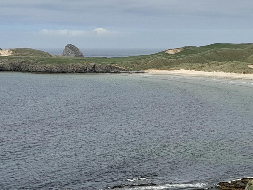 a view of a beach with a mountain in the distance at Jack's place in Balnakeil