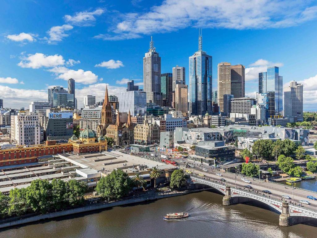 a city skyline with a bridge and a river at Quay West Suites Melbourne in Melbourne