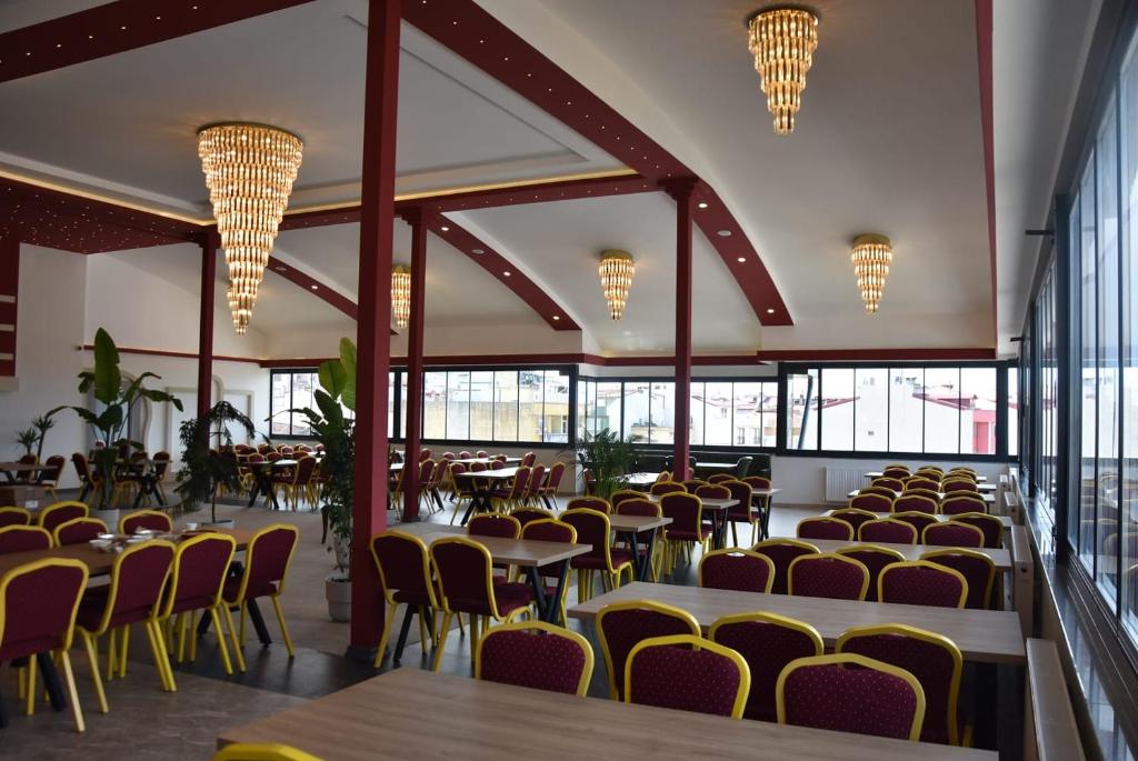 a dining hall with tables and chairs and windows at Görele Liva Otel in Görele