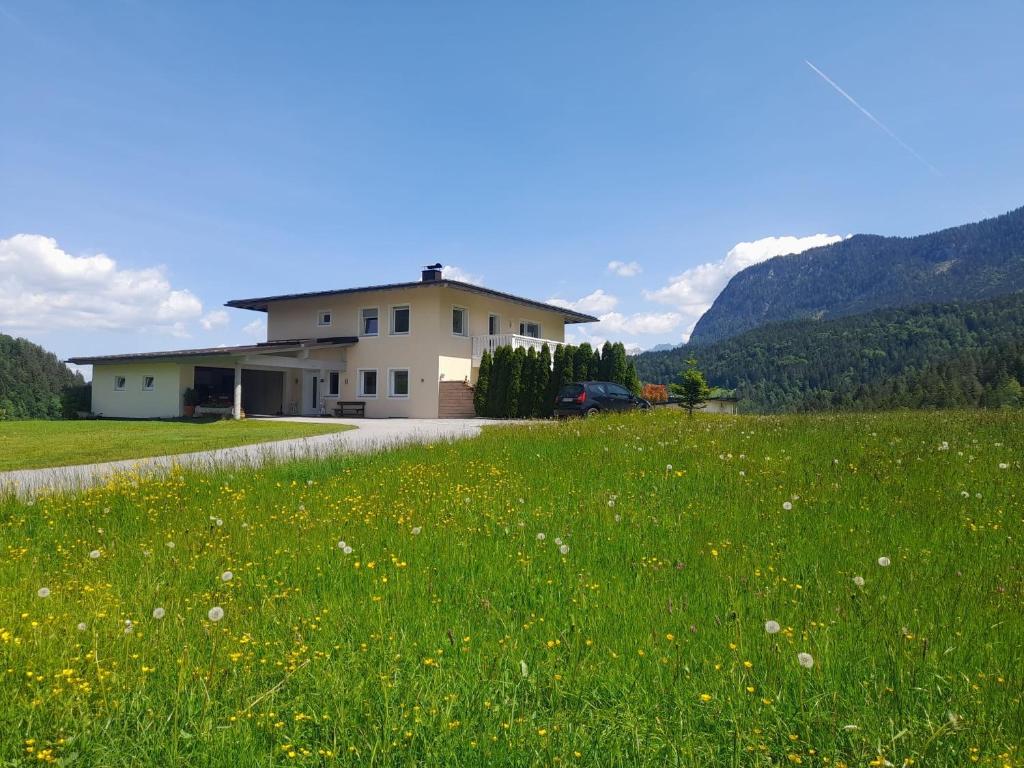 a house in the middle of a field of flowers at Villa Werlberger in Thiersee