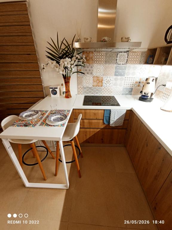a small kitchen with a white table and chairs at ALMAREDo in Bisceglie