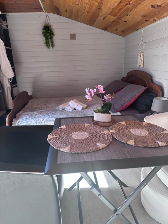 a room with a bed and two tables with flowers on it at Le Petit Farfadet in Flangebouche