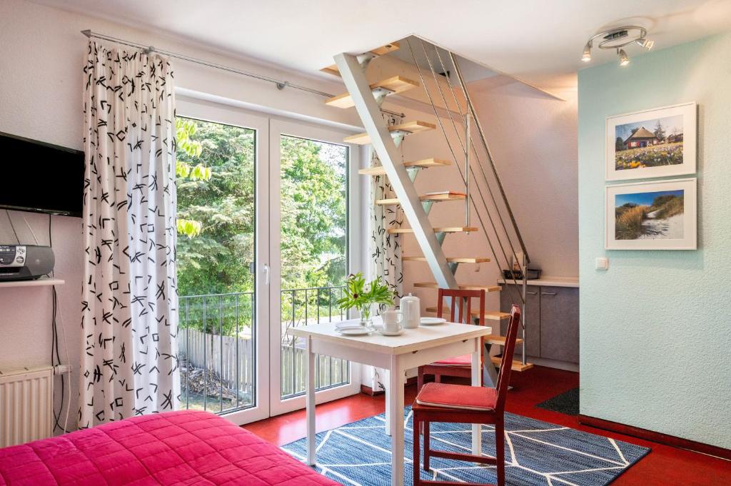 a room with a table and a staircase and a window at Ostsee in Diedrichshagen