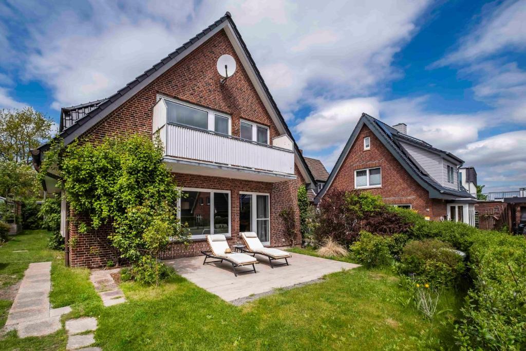 a brick house with a patio with two chairs at Ferienhaus Inge in Büsum
