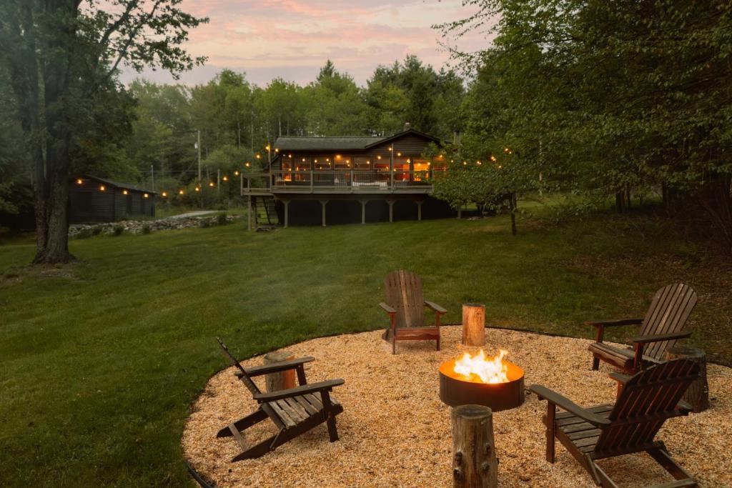 a fire pit in a yard with chairs and a house at Wren Cottage - Design Cabin with Secret Brook in Cochecton