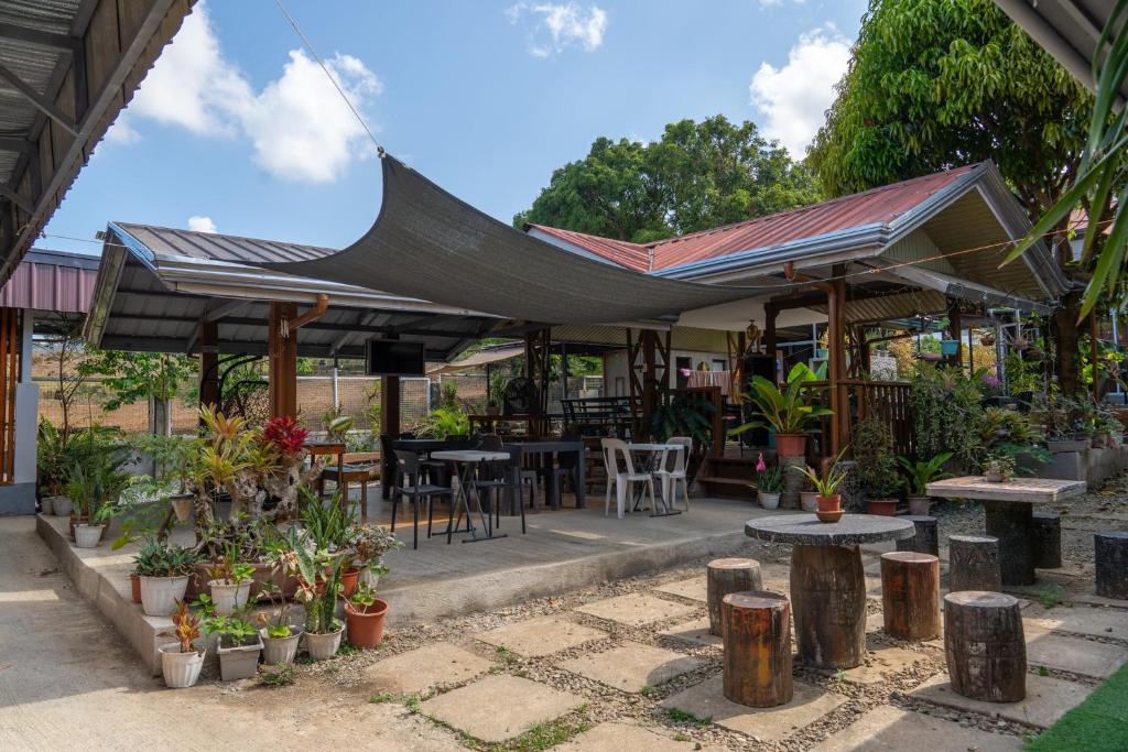 awning over a patio with tables and chairs and plants at La Casa Josefina in Aga