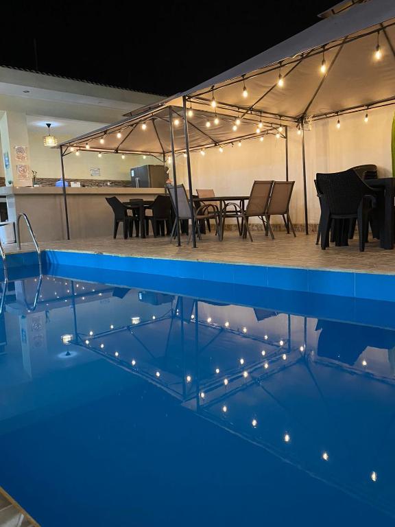 a swimming pool with a table and chairs and lights at La Ruta in Paracas