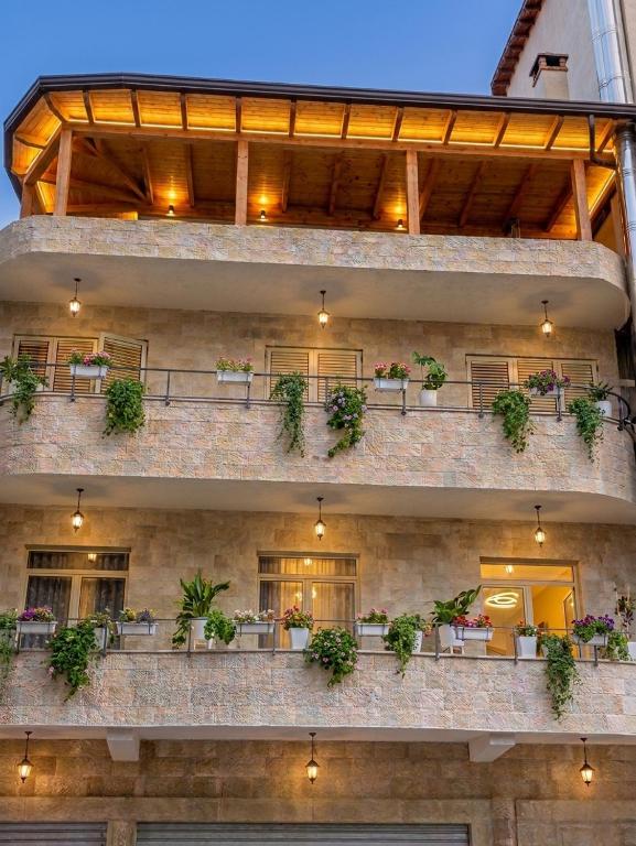 a brick building with potted plants on a balcony at Vila HK in Krujë