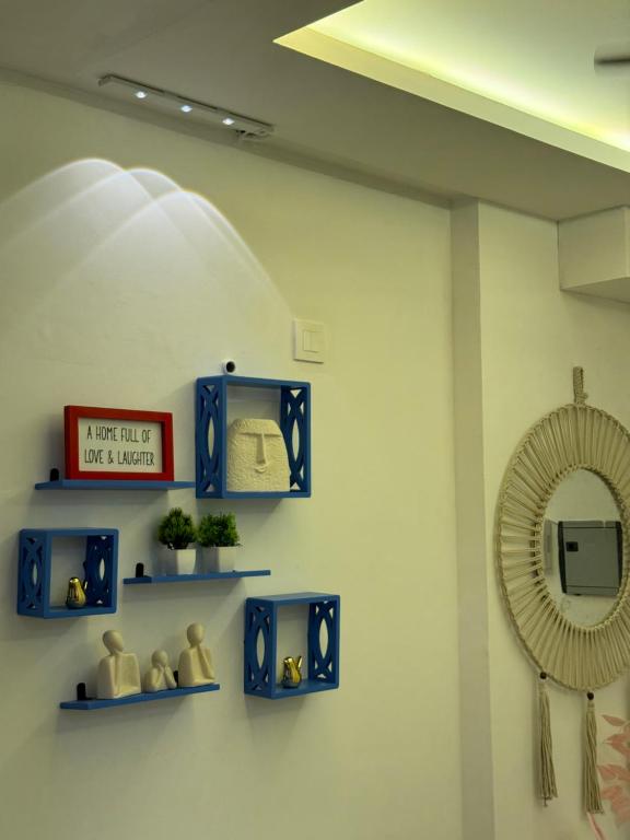 a room with blue shelves and a mirror at Flippy Escapes in Zirakpur