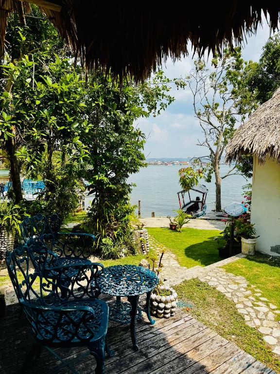 a patio with a table and chairs and the ocean at Mayan Spirit in Flores