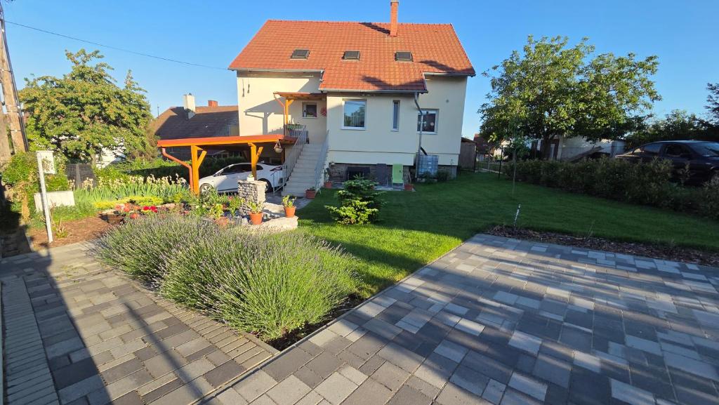 a white house with a red roof and a yard at Dália Apartman in Tihany