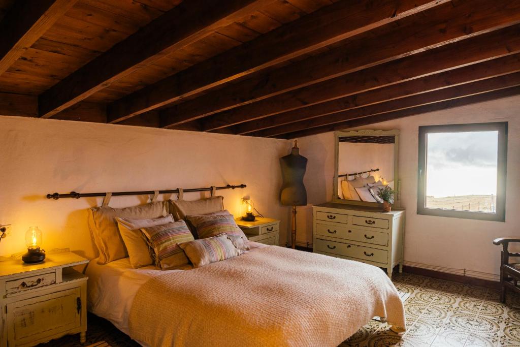 a bedroom with a bed and two dressers and a window at Finca Vilaflor in Vilaflor