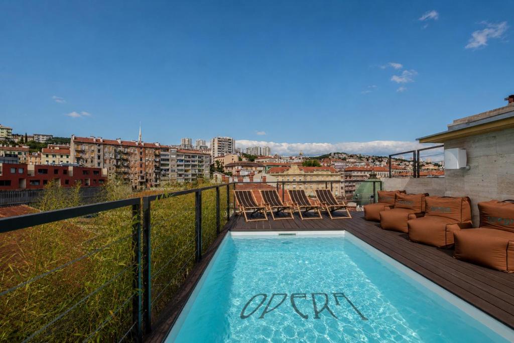 a swimming pool on a balcony with a view of a city at Boutique Hotel OPERA in Rijeka