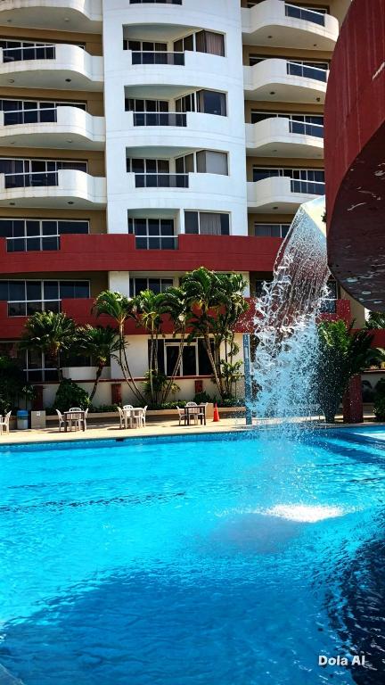 a fountain in a swimming pool in front of a building at Tonsupa Playa Almendro in Tonsupa