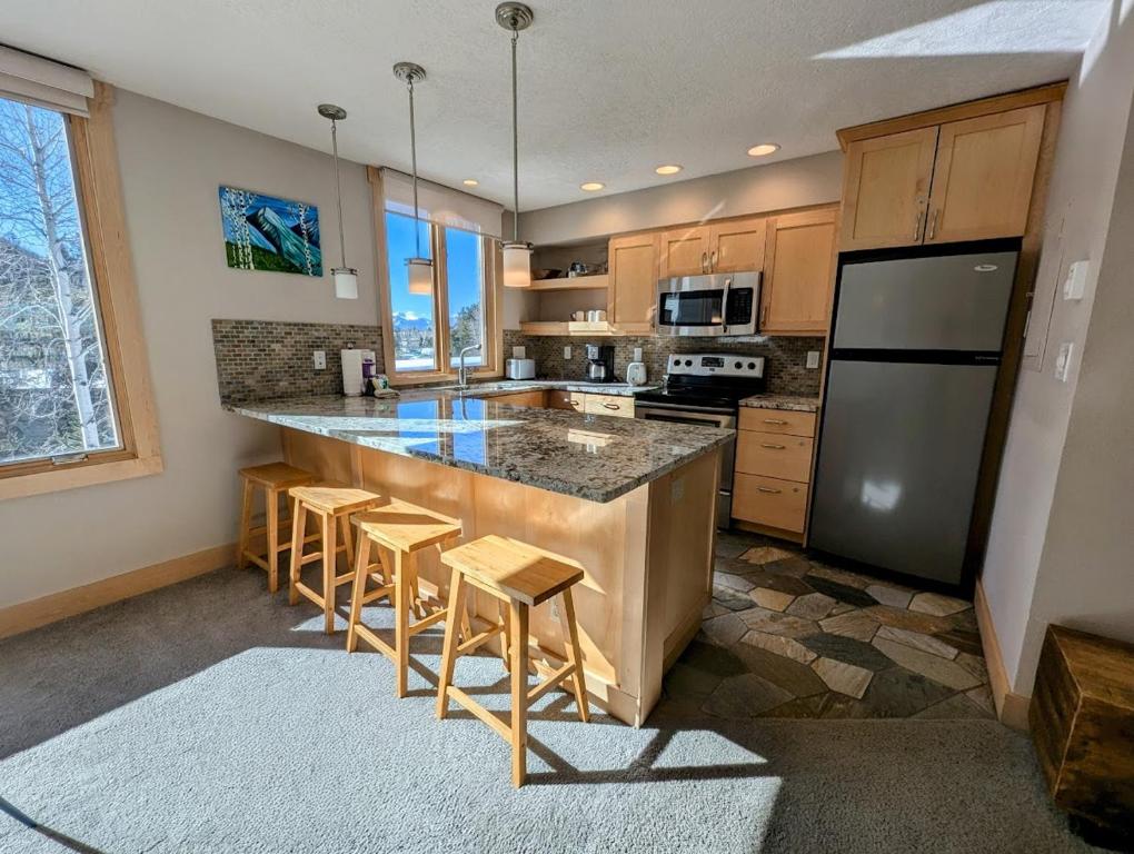 a kitchen with a large island with bar stools at Argentine 1516 by SummitCove Lodging in Colorado in Keystone